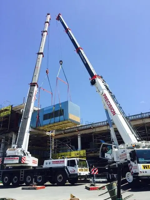 Two Cranes Working Together to Place a Load